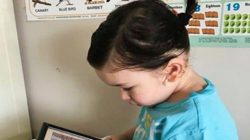 Taimur Ali Khan dons a cute ponytail; stares at daddy Saif Ali Khan’s photo