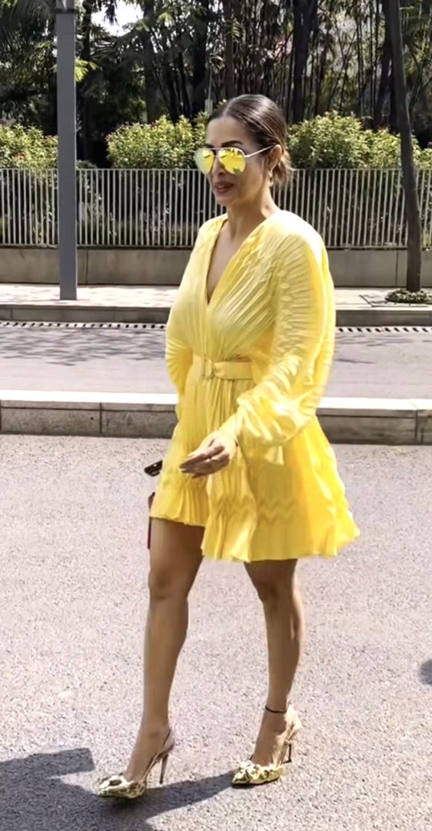 Malaika Arora looks fun and fabulous in a yellow pleated minidress with a pink Valentino handbag 