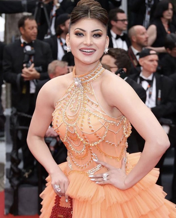 Urvashi Rautela steals the spotlight at Cannes 2023, adorned in an orange frill gown that exudes ethereal beauty and unmatched glamour