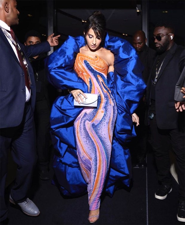 Nora Fatehi set the IIFA 2023 stage ablaze in an orange and blue swirl-embellished gown, with a captivating flouncy blue cape