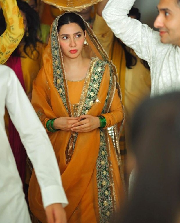 Mahira Khan beams with joy during her Mayoon ceremony, adorned in a vibrant orange Anarkali outfit