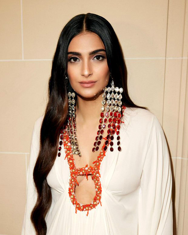 Sonam Kapoor radiates elegance in a flowy white dress, adorned with ombre and ruby-red dangler earrings