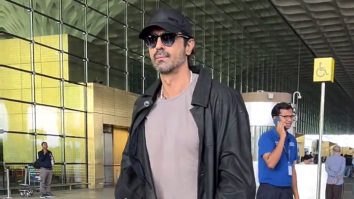Arjun Rampal smiles as he poses for a picture with fans at the airport
