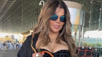 Rakhi Sawant carries a unique purse with her mom’s portrait, shows it to paps at the airport